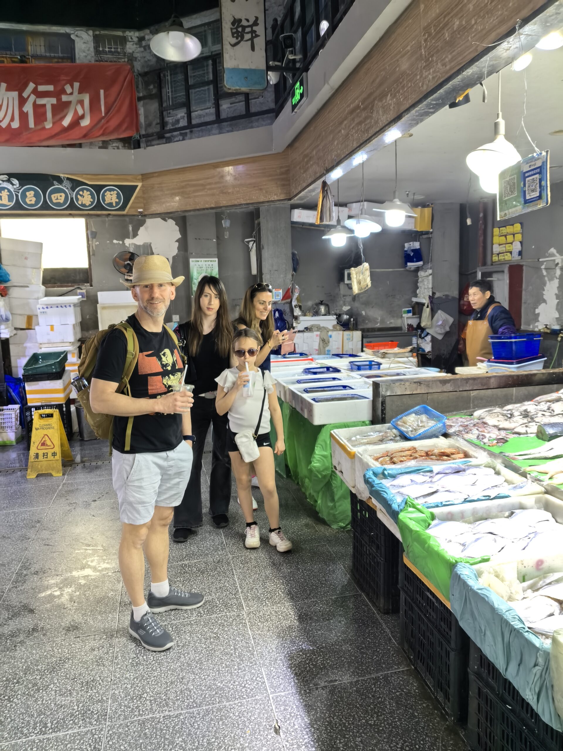 Visitors exploring a seafood stall at a local market in Shanghai