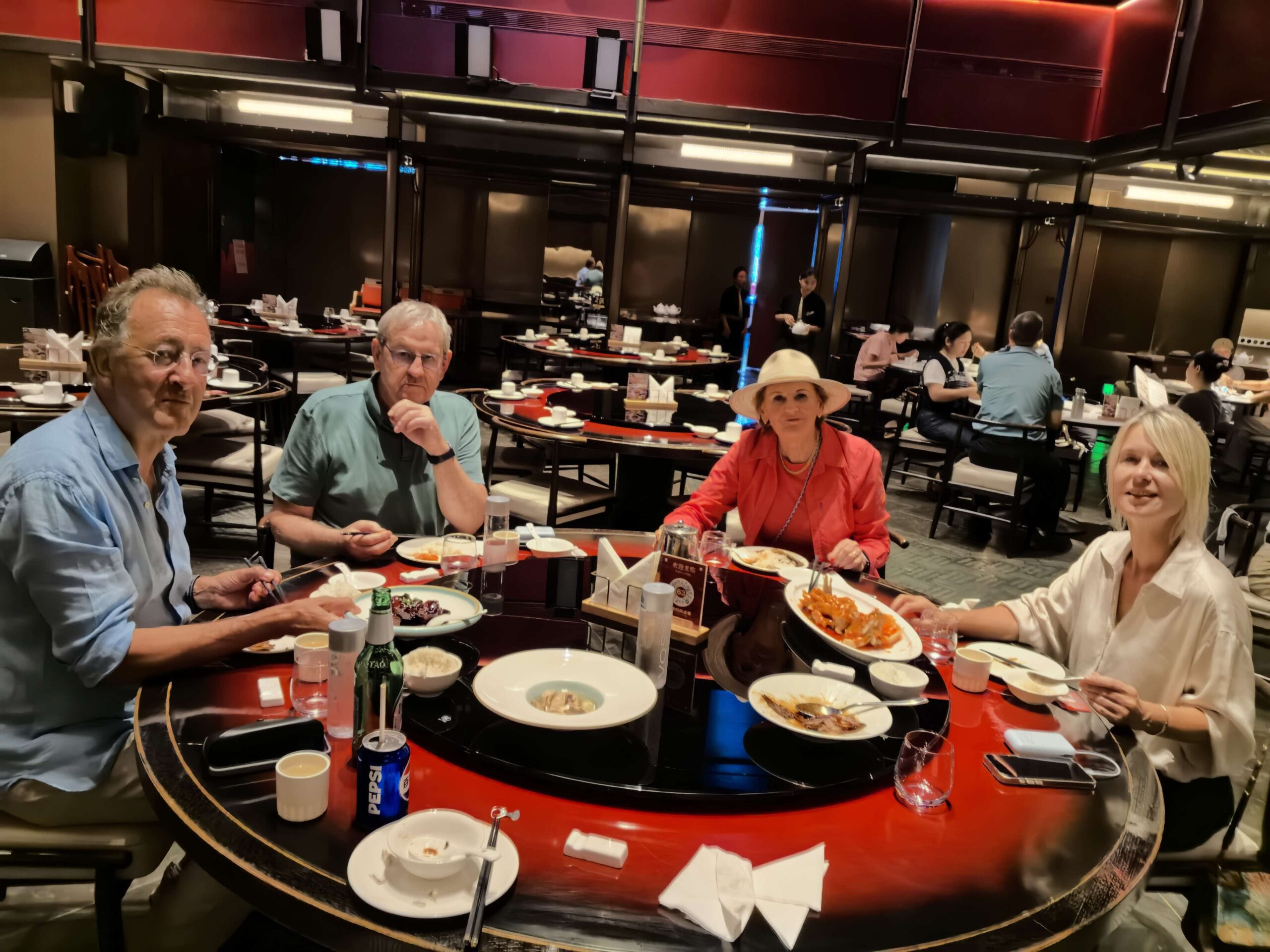 Guests sharing Chinese dishes around a restaurant table in Shanghai