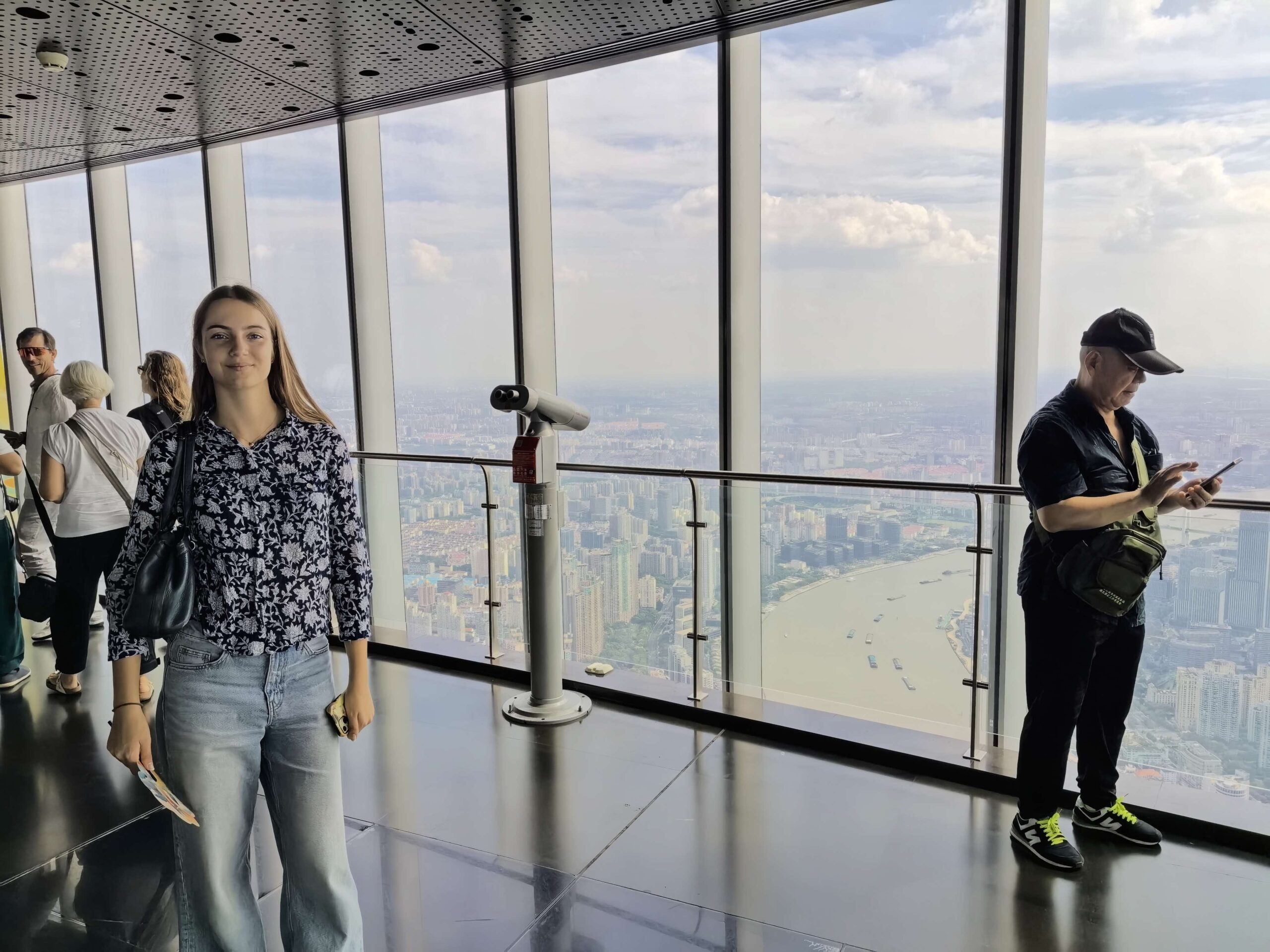 Visitors overlooking the city and Huangpu River from the Shanghai Tower observation deck